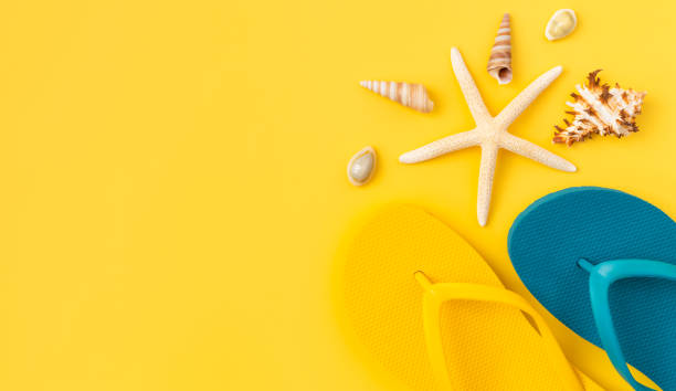 istock Summer time concept, top view with copy space of flip flops and sunglasses with starfish on yellow background. 1484094821