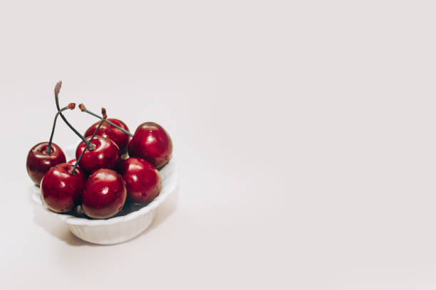 istock Ripe red cherries in white plates on the table 1484097130