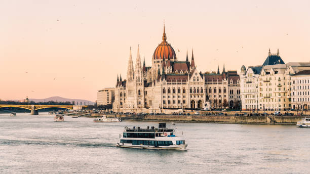 Budapest City Twilight Panorama Hungary Parliament Building Danube River Budapest City Twilight. Sunset twilight panorama over the Parliament Building of Hungary. Riverside of the Danube River with cruising Tourist Tour Boat. Hungarian Parliament Building on the Pest City Side of Budapest. Budapest, Hungary, Eastern Europe budapest danube river cruise hungary stock pictures, royalty-free photos & images