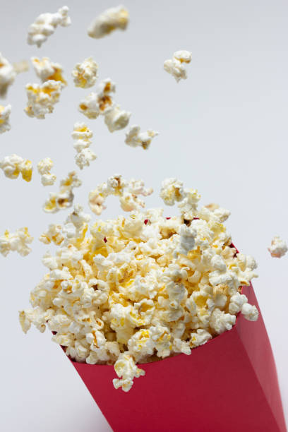 istock Popcorn popping into the air from a red paper bowl. 1484097360