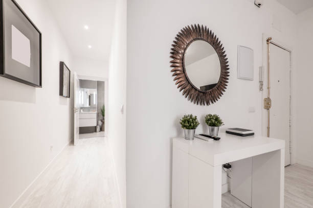 istock Hallway with a white wooden table with a toothed circular mirror and a hallway with light parquet floors 1484097435