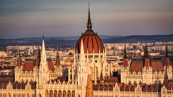 Budapest Hungary Panorama of the Hungarian Parliament Building from above in sunset light. Tele Photo Panorama down towards the Parliament Building also known as the Parliament of Budapest at the Riverside of the Danube River. Hungarian Parliament Building on the Pest City Side of Budapest. Budapest, Hungary, Eastern Europe