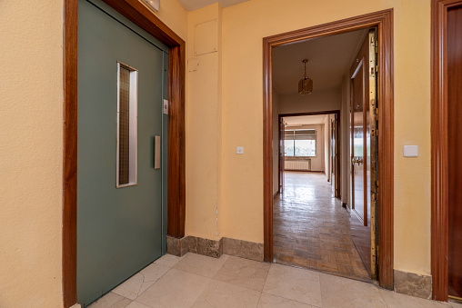 Entrance hall and elevator of an urban residential house with oak parquet floors