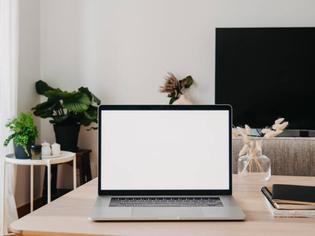 istock Laptop with blank screen on wooden table in home interior. 1484099277