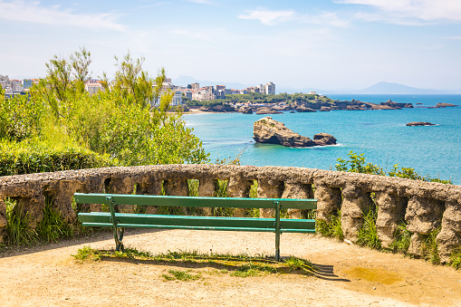 Wooden bench with a scenic view on Roche Ronde rock and the Atlantic Ocean in Biarritz, France