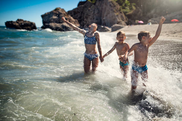 istock Children enjoying huge waves on beach 1484101815