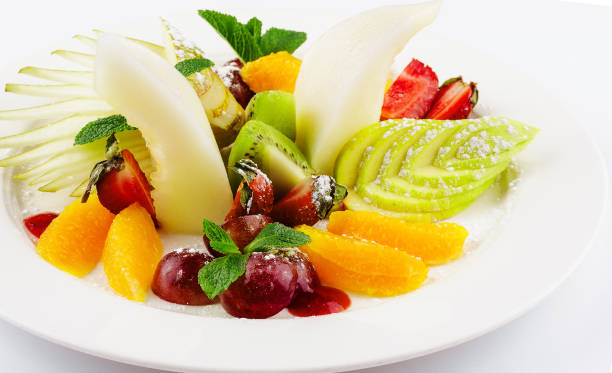 istock Fresh fruit salad on white plate isolated on white 1484101927