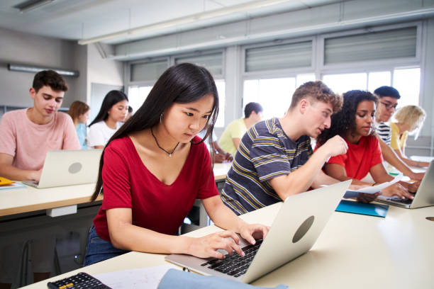 istock A young Asian high school student studies using a laptop computer. A group of classmates in class. Education and technology 1484102302