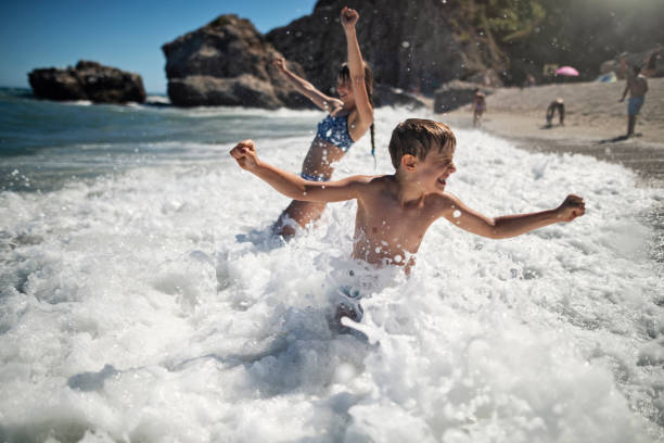 istock Children enjoying huge waves on beach 1484106448