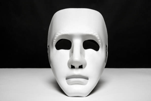 istock An expressionless mask of white color on a smooth white surface and black background 1484106449