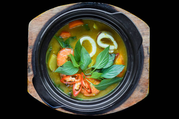 Vietnamese curry with shrimps and potato on black background for a menu