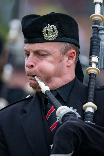 A traditional Scottish bagpiper outside a building in Pitlochry, Scotland, just north of Edinburgh.