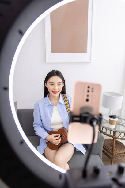 istock Young woman taking online ukulele music guitar lessons tutorial on laptop at home. Learning to play a musical instrument. 1484115506