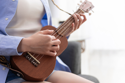 Woman play a song on ukulele