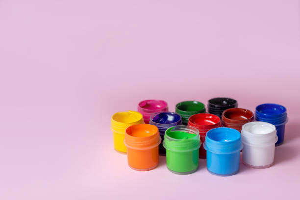 istock Multicolored paints on a pink background. Jars with multi-colored paints. Acrylic, gouache. 1484116774
