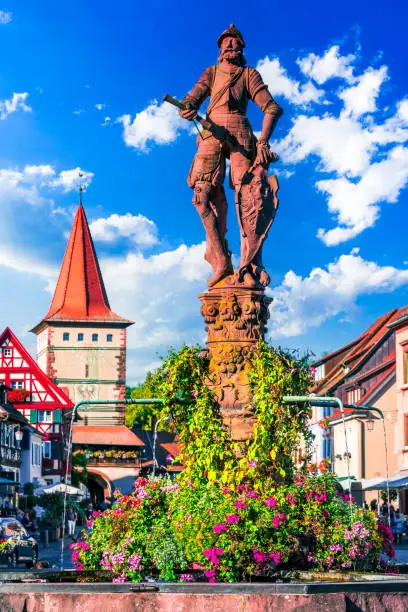 Gengenbach, Germany. Marktplatzbrunnen, beautiful fountain located in the town square, surrounded by charming timber-framed buildings and colorful flower arrangements. Black Forest travel in Baden-Wurttemberg