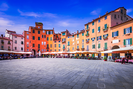 Lucca, Italy - September 2021. Piazza dell'Anfiteatro is a historic amphitheater transformed into a charming square with cafes, shops, and lively atmosphere of Tuscany.