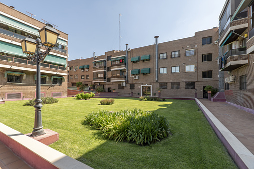 Interior gardens of an urban residential development with grass and lamps