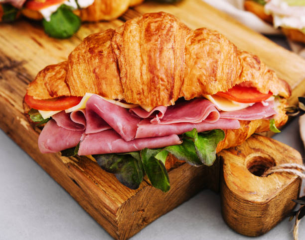 istock Delicious croissant sandwich on wooden board 1484122145