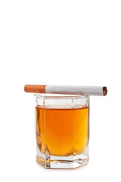 glass of cognac and cigarettes isolated on a white background