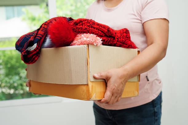 istock Clothes donations in cardboard box for volunteer. 1484125097