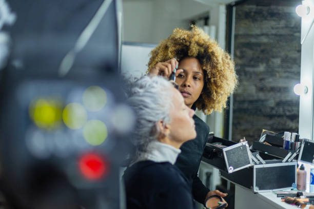 istock Makeup artist performs her work on the model before you start the photo studio 1484126276