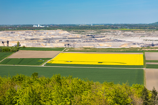 High angle view from the Indemann to a lignite pit mine with a yellow rape field in the foreground