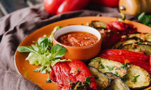 Grilled colorful vegetables, aubergines, zucchini, pepper with spice and green basil stock photo
