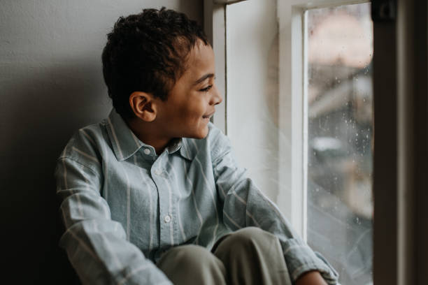 istock Little multiracial boy looking out of window. 1484133991