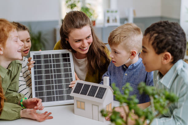 istock Young teacher with solar panel learning pupils about solar energy. 1484134051