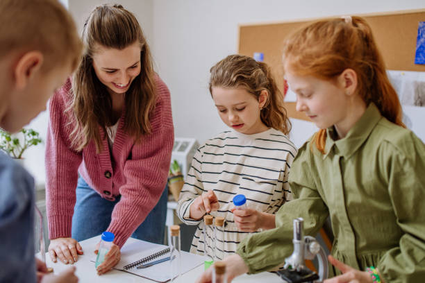 istock Young teacher doing chemistry experiment with pupils during science education. 1484134200