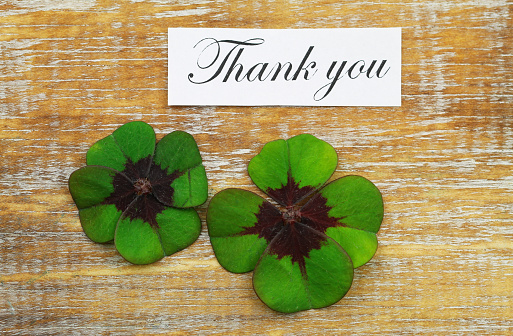 Thank you card with two shamrocks on wooden surface