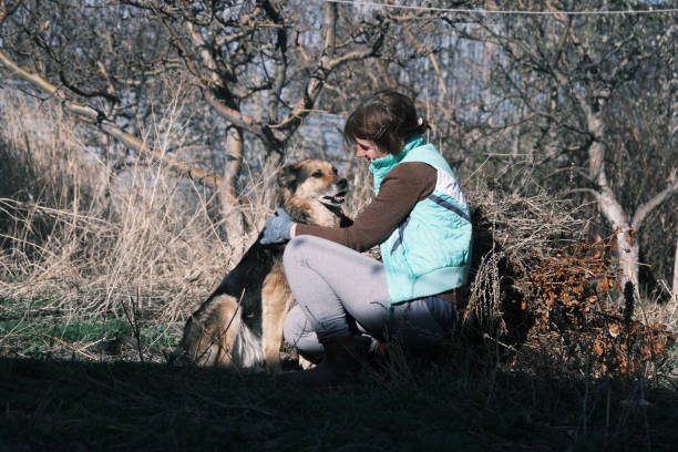 Woman and dog are communicating during garden work