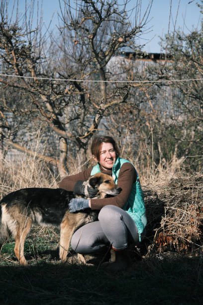 istock Woman and dog are communicating during garden work 1484136724