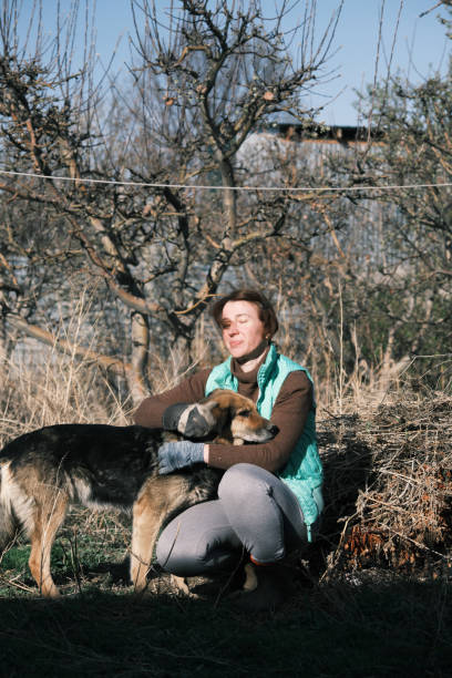 istock Woman and dog are communicating during garden work 1484136962
