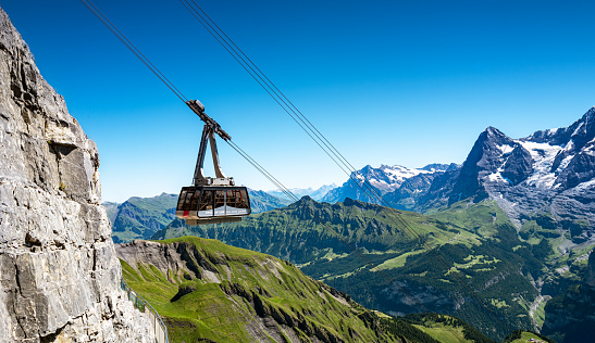 Murren, Switzerland - July 2, 2022: The overhead cable car arriving Schilthorn from Murren station taking hikers and tourists to the top of Schilthorn for skyline views of Eiger, Monch and Jungfrau.