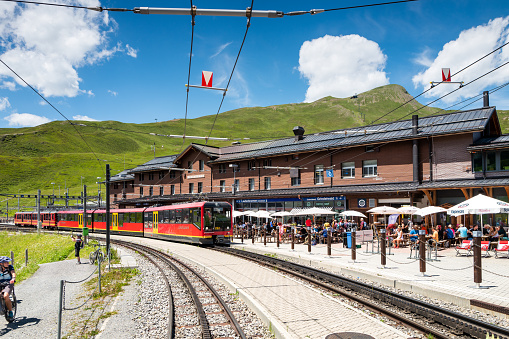 Kleine Scheidegg, Bernese Oberland, Switzerland - July 3, 2022:  The famous Red Jungfraubahn train that travels to and from Jungfraujoch and Kleine Scheidegg, passing through the Mountain Eiger and making it the highest railway line in Europe.  UNESCO World Heritage Site