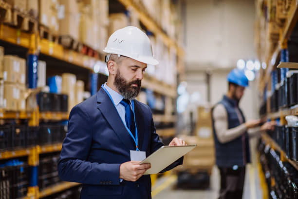 istock Manager in suit controlling goods in a warehouse. 1484137424