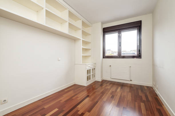 istock An empty room with a white lacquered wooden tall bookcase with a low cabinet and a reddish parquet floor 1484137654