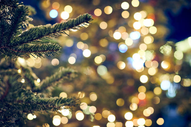 istock Christmas tree covered snow with yellow garlands lights and bokeh copy space with sparkled bokeh 1484139978