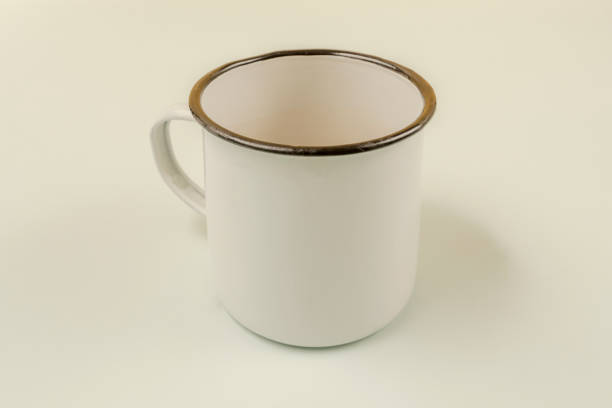 istock A white enameled metal mug with a black rim on a smooth white surface 1484140903