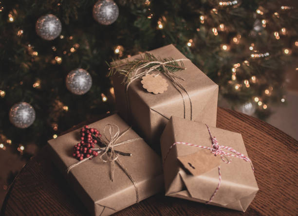 istock Christmas gift wrapped in brown craft paper on the table 1484141163