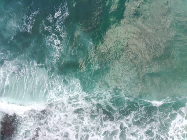 istock blue and green waves crashing against the reef making a beautiful natural pattern. 1484142182