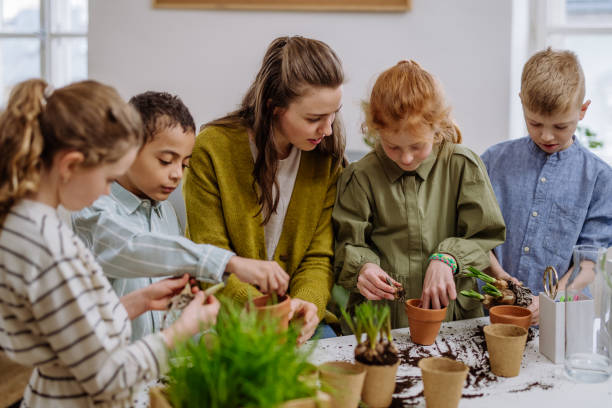 istock Young teacher learning pupils how to take care about plants. 1484144214