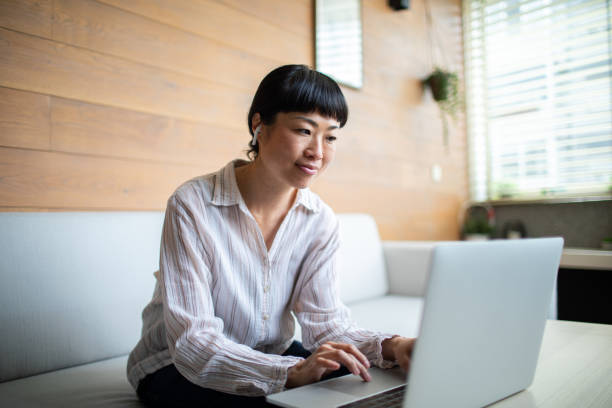 istock Young Asian woman working on her laptop from home 1484147093