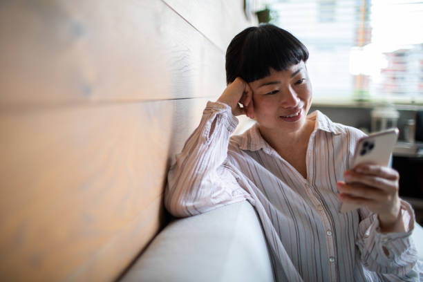 istock Young Asian woman using a smart phone at home 1484147153