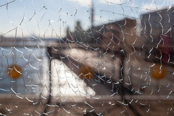 istock Broken glass, cracks on the window glass. There is a river and a city 1484147815