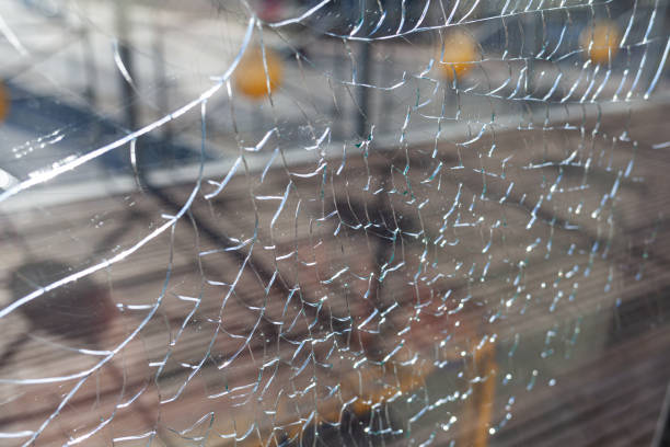istock Broken glass, cracks on the window glass. There is a river and a city 1484148015
