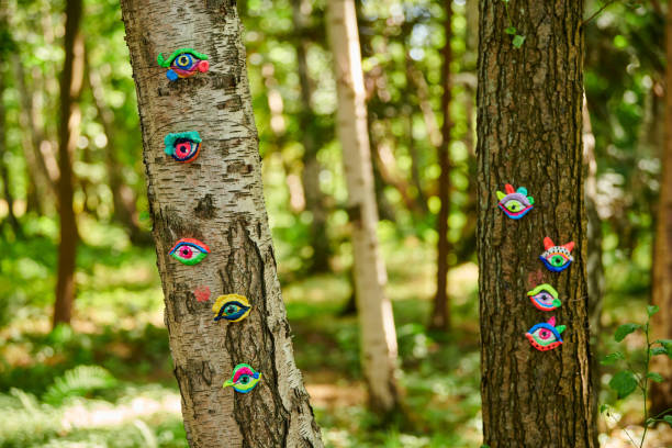 istock Art object of human eyes on tree trunk in green forest background, trees sight feeling ecological concept 1484148193