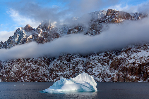 Bank of low cloud and the mountains along Northwest Fjord in the far reaches of Scoresbysund in eastern Greenland.